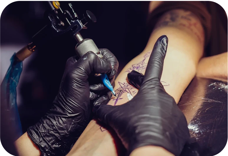tattoo artist inking a persons arm